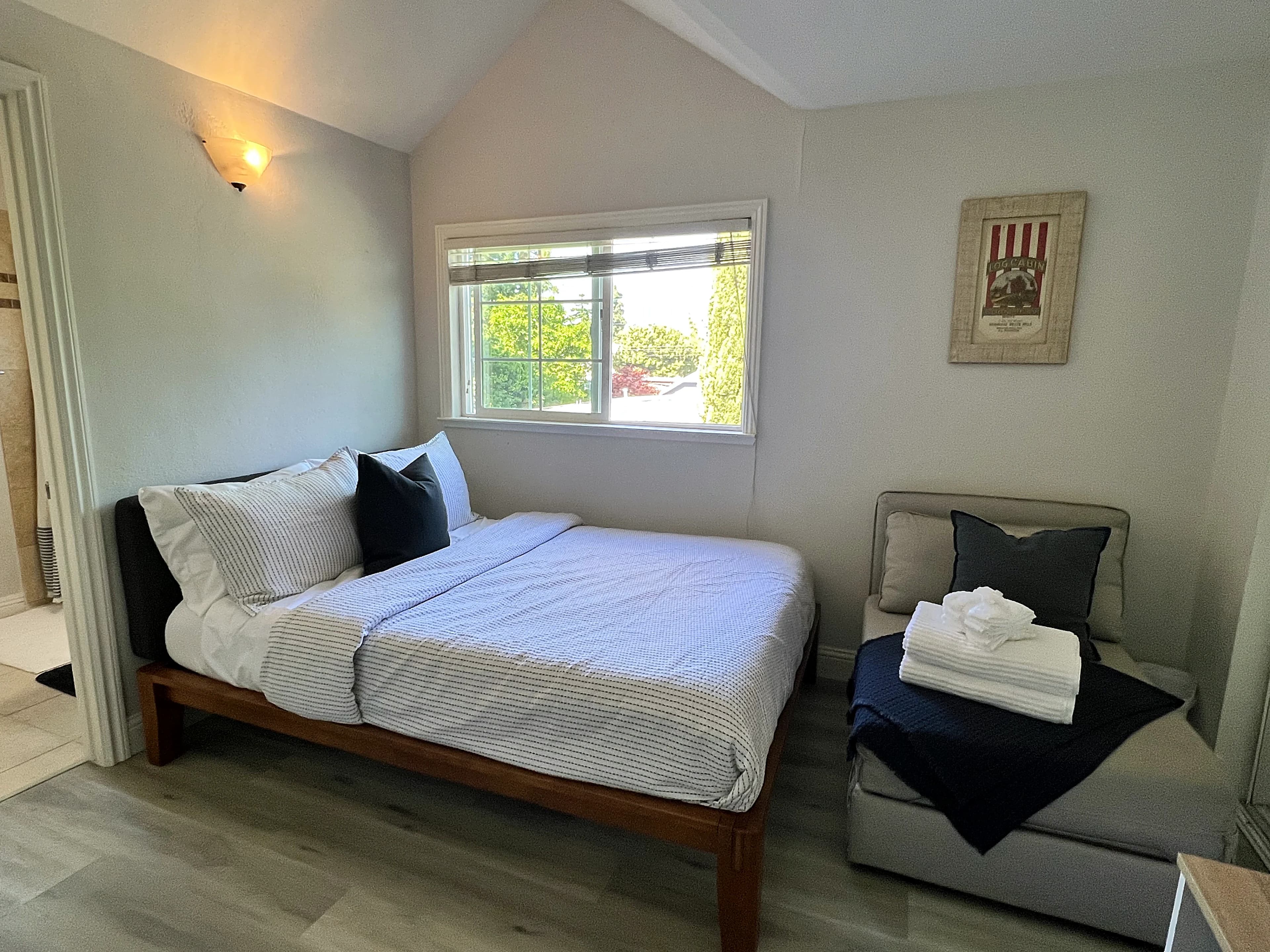 West room: the bed under the window, with the sitting corner