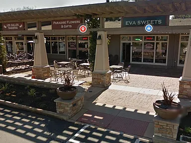 A sweets shop and a florist with tables outside